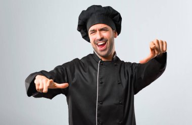 Birisi parmak ile işaret ve gri arka plan üzerinde çok gülüyor siyah üniformalı erkeklere Şef