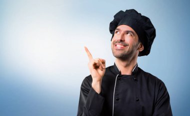 Harika bir fikir işaret parmağı ile işaret ve mavi arka plan üzerinde seyir siyah üniformalı erkeklere Şef