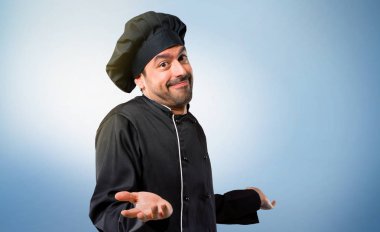 Şef adam siyah üniforma önemsiz yapma ve şüpheler jest omuz ve ellerde üzerinde mavi arka plan kaldırma sırasında