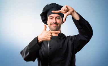 Şef yüz odaklanarak siyah üniformalı erkeklere. Mavi arka plan çerçeveleme sembolü