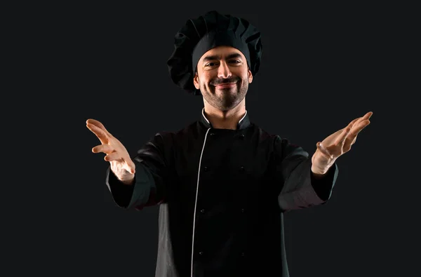 Chef Hombre Uniforme Negro Extendiendo Las Manos Lado Sonriendo Para —  Fotos de Stock
