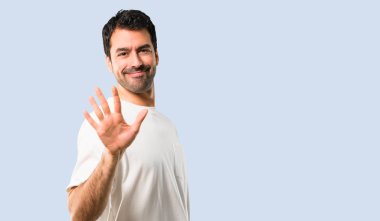 Beyaz gömlek beş parmak izole mavi arka plan ile sayma ile genç adam