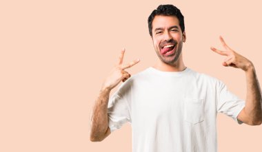 Komik göz izole koyu sarı arka plan üzerinde olan kamera dil gösterilen beyaz gömlek ile genç adam