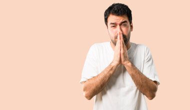 Beyaz gömlek genç adamla birlikte palm tutar. Kişi için bir şey izole koyu sarı arka plan üzerinde sorar