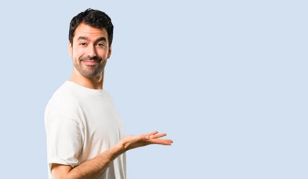 Jovem Com Camisa Branca Apresentando Produto Uma Ideia Enquanto Olha — Fotografia de Stock