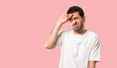 Yorgun ve hasta ifade izole pembe bir arka plan üzerinde beyaz gömlek ile genç adam