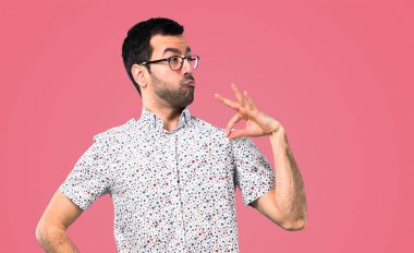 Gözlüklü kibirli ve kendini beğenmiş yakışıklı adam kendini pembe bir arka plan üzerinde kavram seviyorum
