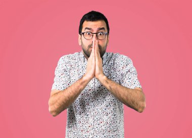 Gözlüklü, pembe arka plan yalvaran yakışıklı adam