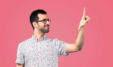 Pembe arka plan şeffaf ekranda dokunmadan gözlüklü yakışıklı adam