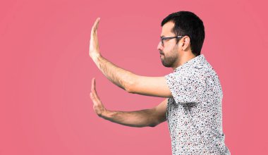 Bir şey, pembe arka plan iterek gözlüklü yakışıklı adam