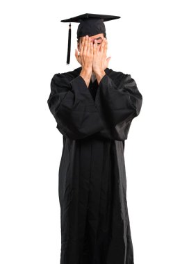 Adamın gözleri eller tarafından kapsayan ve izole beyaz arka plan parmaklara bakarak onun mezuniyet günü üniversite