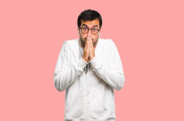 Gözlük ve dinleme müzik tutar palm birlikte olan adam. Kişi için bir şey, pembe arka plan sorar