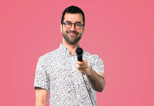 Przystojny Mężczyzna Okularach Śpiewając Mikrofonem Różowym Tle — Zdjęcie stockowe