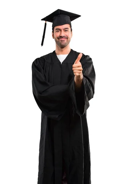 毕业那天 大学里的男人做了一个竖起大拇指的手势 微笑着 因为在孤立的白色背景下发生了一些好事 — 图库照片