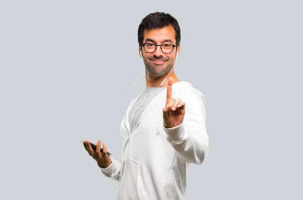 Человек Очках Слушающая Музыка Показывает Поднимает Палец Знак Лучшего Сером — стоковое фото