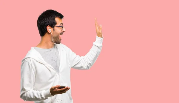 Hombre Con Gafas Escuchando Música Saludando Con Mano Con Expresión —  Fotos de Stock