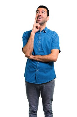 Yakışıklı adam ayakta ve bir fikir düşünce mavi gömlek ile