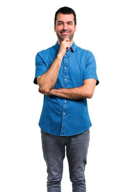 Yakışıklı adam ayakta ve bir fikir düşünce mavi gömlek ile