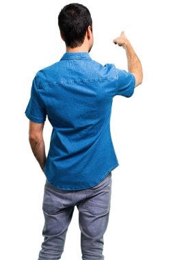 Mavi gömlek geri işaret parmağı ile işaret ile yakışıklı adam