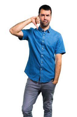 Başparmak aşağı negatif ifade işaretiyle gösterilen mavi gömlek ile yakışıklı adam