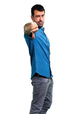 Başparmak aşağı negatif ifade işaretiyle gösterilen mavi gömlek ile yakışıklı adam