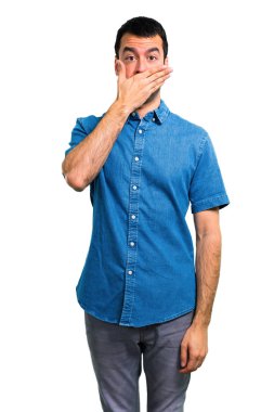 Ellerle ağız kapsayan mavi gömlek ile yakışıklı adam