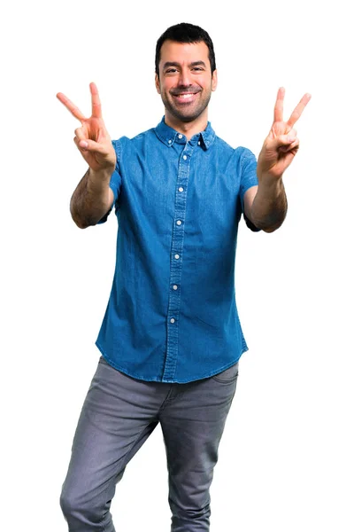 Knappe Man Met Blauwe Shirt Glimlachend Overwinning Teken Tonen — Stockfoto