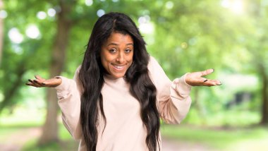 Genç afro Amerikalı kadın omuz açık havada kaldırma sırasında önemli jest yapma