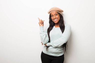 Harika bir fikir parmak ile işaret ve ararken beyaz duvar genç afro Amerikalı kadın