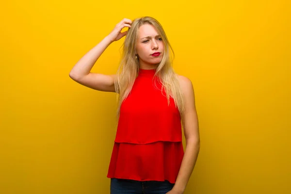 Menina Jovem Com Vestido Vermelho Sobre Parede Amarela Com Dúvidas — Fotografia de Stock