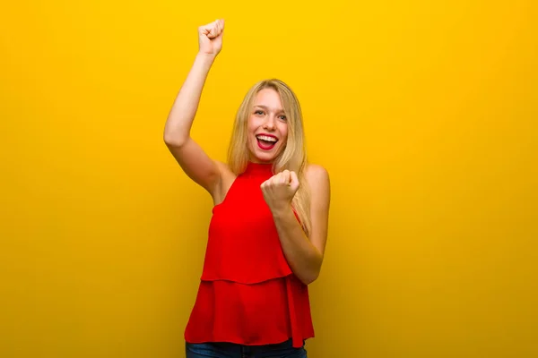 Giovane Ragazza Con Abito Rosso Sul Muro Giallo Che Celebra — Foto Stock