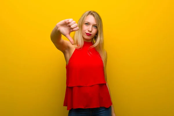 Mladá Dívka Červenými Šaty Žluté Zeď Znázorňující Palec Dolů Cedulka — Stock fotografie