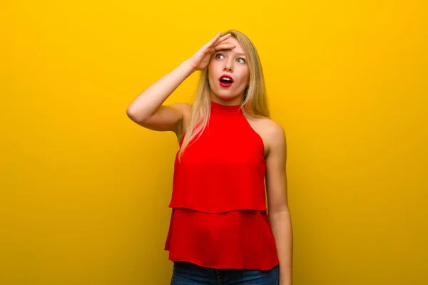 Chica Joven Con Vestido Rojo Sobre Pared Amarilla Con Sorpresa —  Fotos de Stock