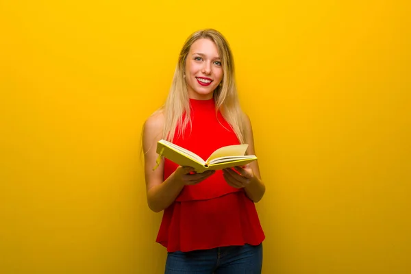 Jovem Com Vestido Vermelho Sobre Parede Amarela Segurando Livro Dando — Fotografia de Stock