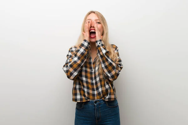 Chica Joven Rubia Sobre Pared Blanca Gritando Anunciando Algo —  Fotos de Stock