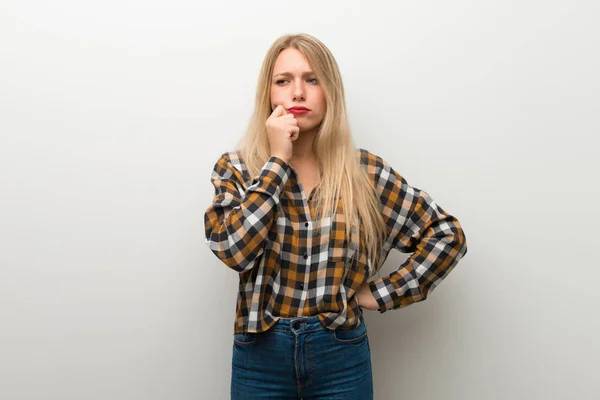 Blonde Young Girl White Wall Having Doubts — Stock Photo, Image