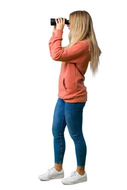 Genç bir kız ve izole beyaz arka plan üzerinde dürbün ile mesafe seyir tam uzunlukta bir atış