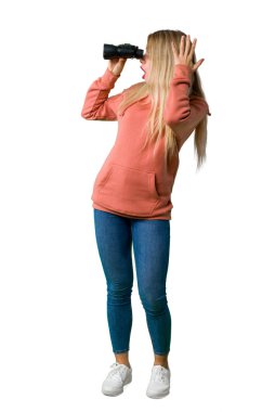 Genç bir kız ve izole beyaz arka plan üzerinde dürbün ile mesafe seyir tam uzunlukta bir atış