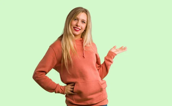 Young Girl Pointing Back Presenting Product Green Background — Stock Photo, Image
