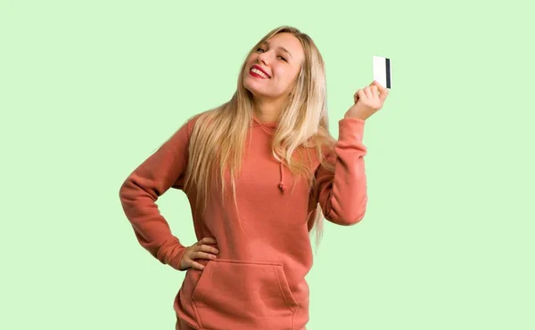Jong Meisje Houdt Van Een Credit Card Denken Groene Achtergrond — Stockfoto