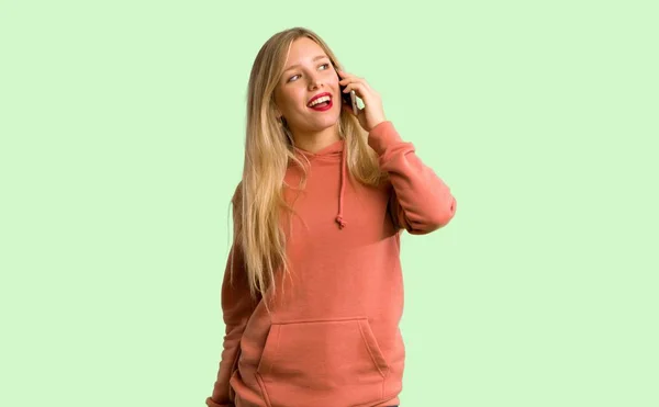 Молодая Девушка Ведет Разговор Мобильным Телефоном Зеленом Фоне — стоковое фото