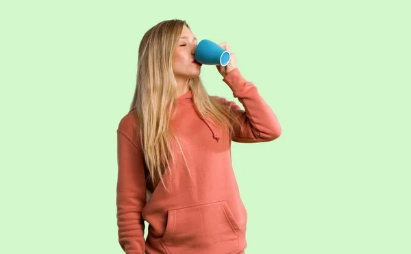 Egy Csésze Forró Kávét Zöld Háttérrel Rendelkező Fiatal Lány — Stock Fotó