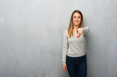 Genç kadın dokulu duvar üzerinde parmak seni kendinden emin bir ifadesiyle işaret