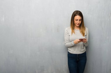 Genç kadın dokulu duvar mobil ileti gönderme