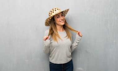 Genç kadın şapka ile dokulu duvar