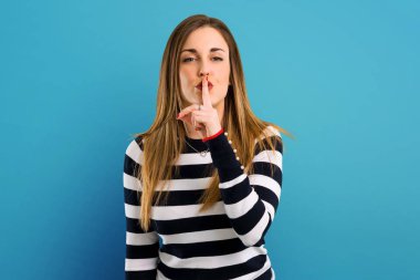 Ağız ve sessizlik bir jest mavi arka plan üzerinde kapanış bir işaret gösteren sarışın youn kız