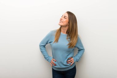 Silah, kalça ile poz ve gülerek izole beyaz arka plan üzerinde sarışın kadın