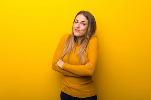 Mujer Joven Sobre Fondo Amarillo Haciendo Gesto Dudas Mientras Levanta —  Fotos de Stock