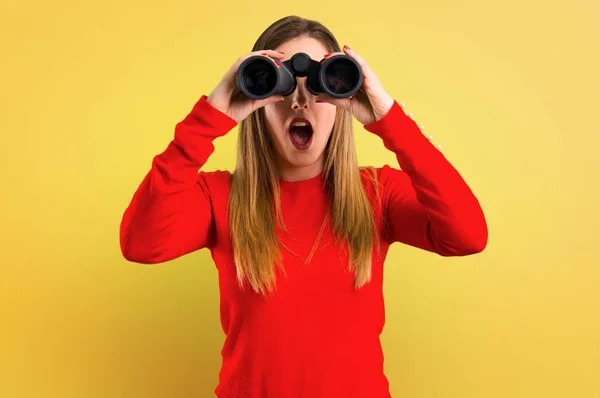 Jovem Loira Com Binóculos Fundo Amarelo — Fotografia de Stock