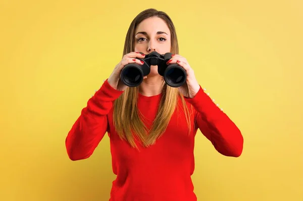 Mujer Rubia Joven Con Prismáticos Sobre Fondo Amarillo —  Fotos de Stock